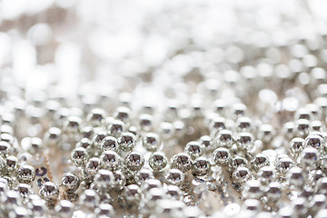 Image showing close up of silver beads on shiny sequined texture