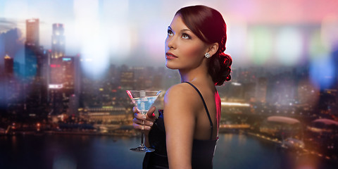 Image showing smiling woman holding cocktail over night city