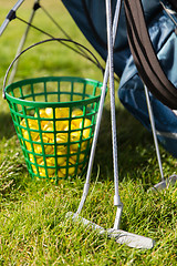 Image showing close up of golf club and balls in basket on grass