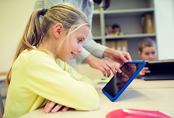 Image showing little girl with teacher and tablet pc at school