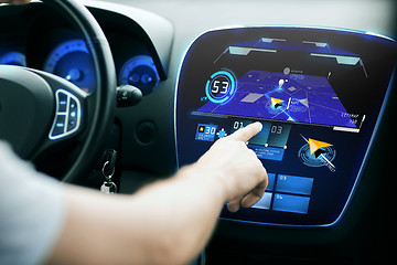 Image showing male hand using navigation system on car dashboard