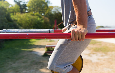 Image showing young man exercising on parallel bars outdoors