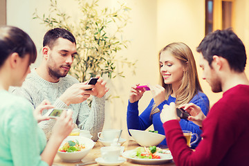 Image showing friends with smartphones taking picture of food
