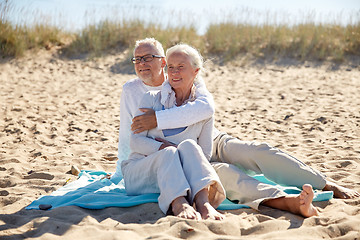 Image showing happy senior couple hugging on summer beach