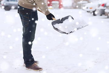 Image showing closeup of man digging snow with shovel near car