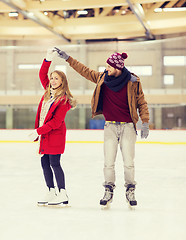 Image showing happy couple holding hands on skating rink