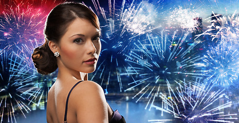 Image showing beautiful woman with diamond earring over firework