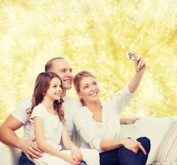 Image showing happy family with camera at home