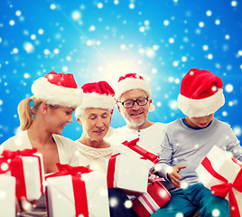 Image showing happy family in santa helper hats with gift boxes