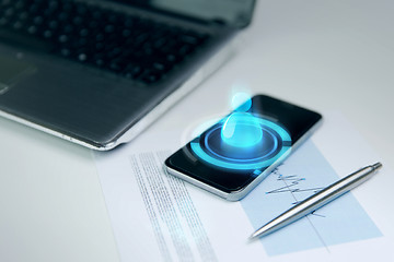 Image showing close up of smartphone, laptop and pen on table