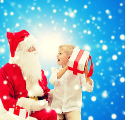 Image showing smiling little boy with santa claus and gifts