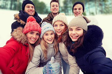 Image showing group of smiling friends taking selfie outdoors