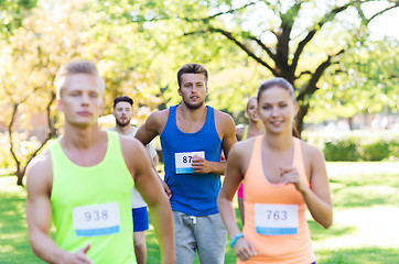 Image showing happ young sportsmen racing wit badge numbers