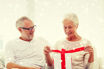 Image showing happy senior couple with gift box at home