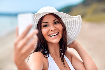 Image showing smiling young woman taking selfie with smartphone