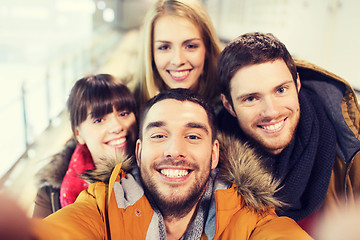 Image showing happy friends taking selfie on skating rink