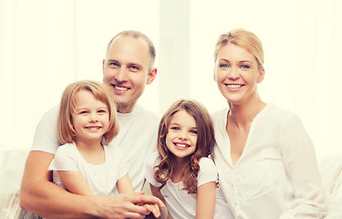 Image showing smiling parents and two little girls at home