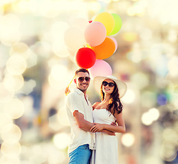 Image showing smiling couple with air balloons outdoors