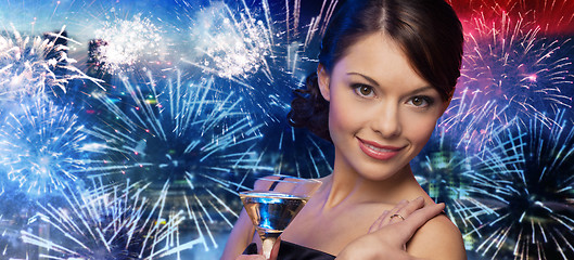 Image showing smiling woman with cocktail over firework in city