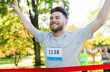 Image showing happy young male runner winning on race finish