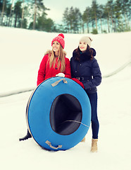 Image showing happy girl friends with snow tubes outdoors