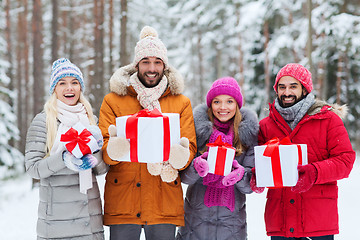 Image showing happy friends with gift boxes in winter forest