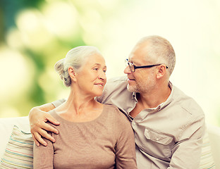 Image showing happy senior couple hugging on sofa at home