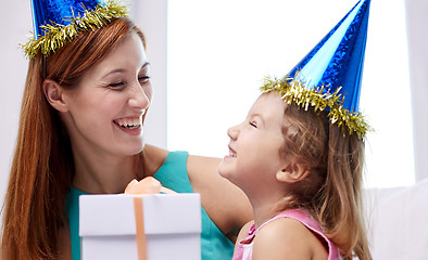 Image showing happy mother and child in party caps with gift box