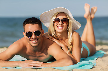 Image showing happy couple in swimwear lying on summer beach