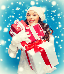 Image showing woman in sweater and hat with many gift boxes