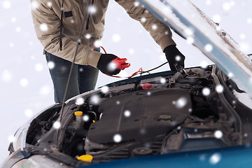 Image showing closeup of man under bonnet with starter cables