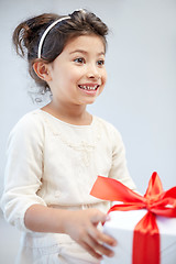 Image showing happy little girl with gift box at home