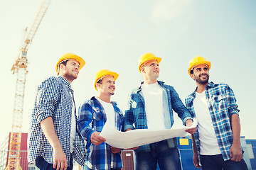 Image showing group of builders with tablet pc and blueprint