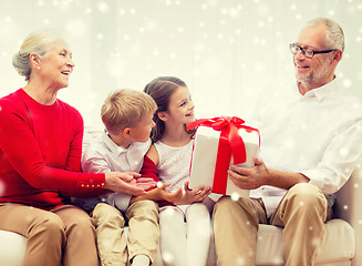 Image showing smiling grandparents and grandchildren with gift