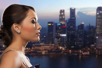 Image showing woman with diamond earring over night city
