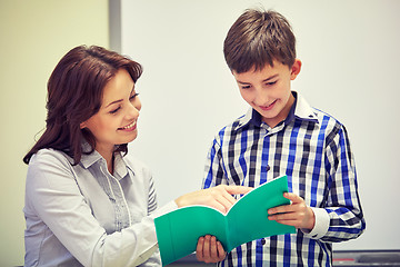 Image showing school boy with notebook and teacher in classroom