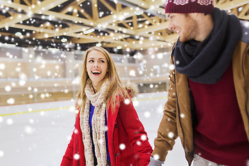 Image showing happy couple holding hands on skating rink