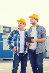 Image showing smiling builders with tablet pc outdoors