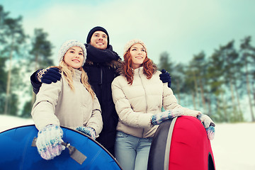 Image showing group of smiling friends with snow tubes