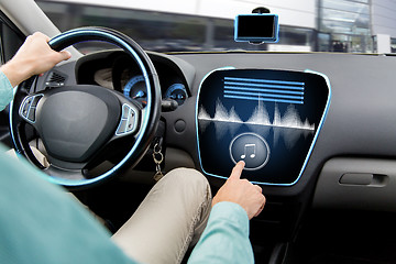 Image showing close up of man driving car with audio system