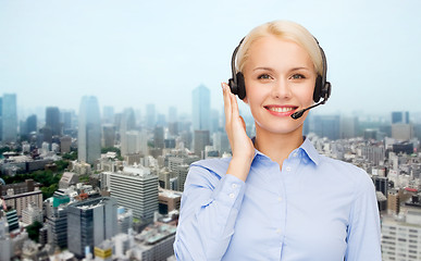 Image showing helpline operator in headset over city background