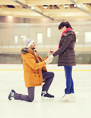 Image showing happy couple with engagement ring on skating rink