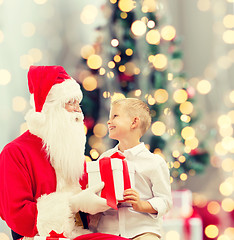 Image showing smiling little boy with santa claus and gifts