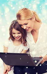Image showing smiling mother and little girl with laptop