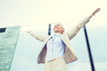 Image showing young smiling businesswoman over office building