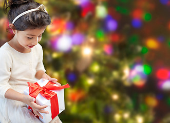 Image showing happy little girl with present over lights