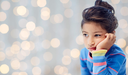 Image showing sad little girl over holidays lights background