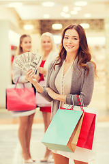 Image showing young women with shopping bags and money in mall