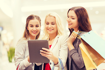 Image showing happy young women with tablet pc and shopping bags