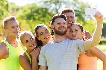 Image showing happy friends taking selfie with smartphone